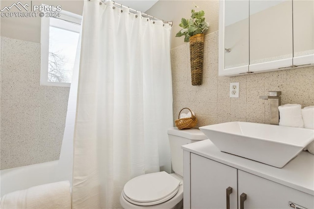 full bathroom with backsplash, toilet, tile walls, shower / tub combo, and vanity