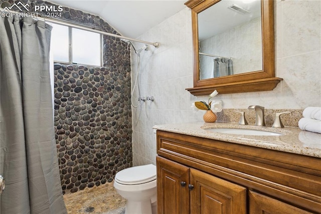 bathroom with vanity, toilet, a shower with shower curtain, and vaulted ceiling