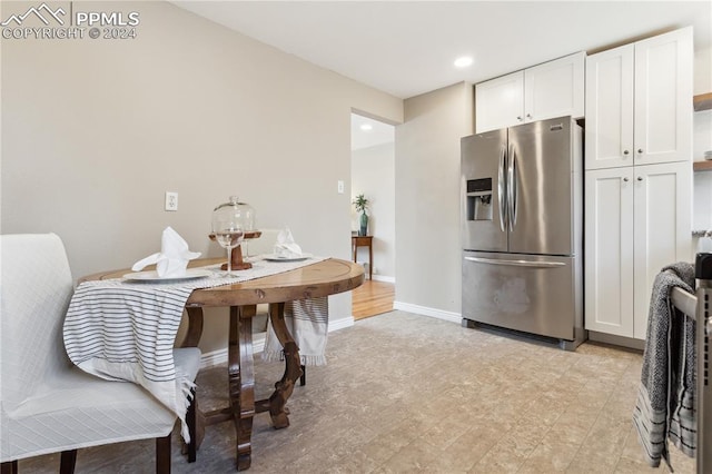 kitchen featuring white cabinets and stainless steel refrigerator with ice dispenser