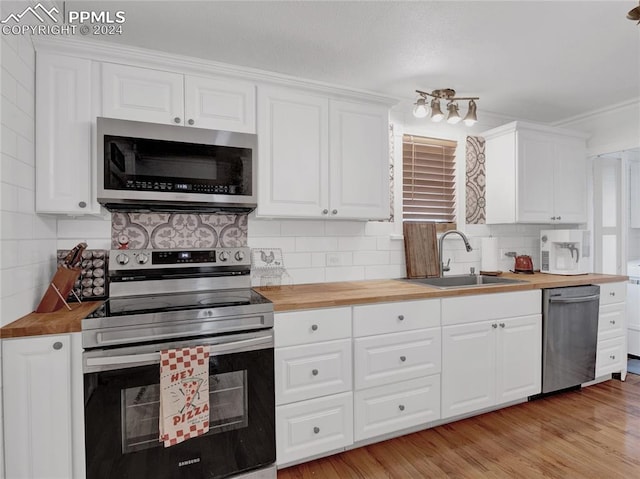 kitchen featuring light hardwood / wood-style flooring, stainless steel appliances, butcher block counters, and sink