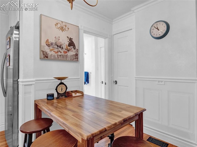 dining room featuring ornamental molding and wood-type flooring