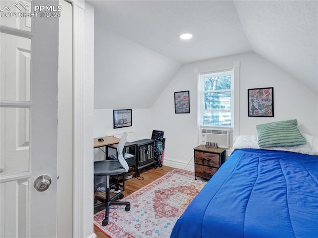 bedroom with lofted ceiling, hardwood / wood-style floors, and cooling unit