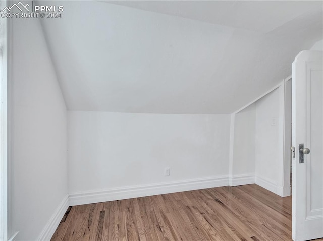 additional living space featuring hardwood / wood-style floors and vaulted ceiling