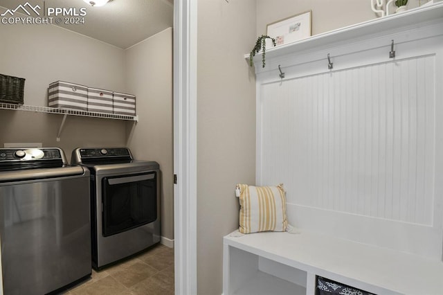 clothes washing area featuring washing machine and clothes dryer and light tile patterned floors