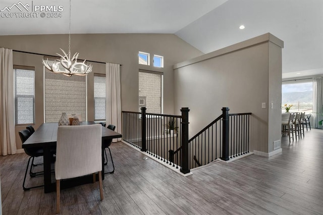 dining area with vaulted ceiling, hardwood / wood-style floors, and a notable chandelier