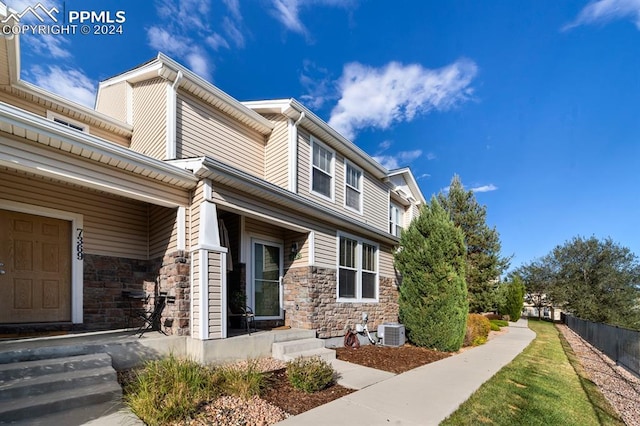 7375 Sandy Springs Pt, Fountain, CO 80817 - view of home's exterior featuring stone siding, cooling unit, and fence