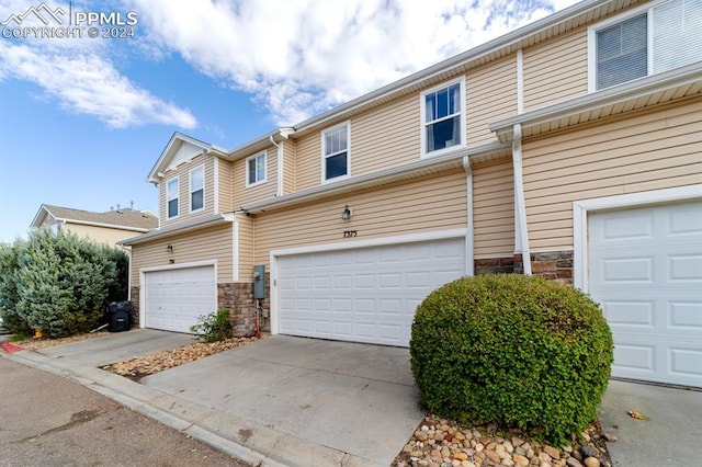7375 Sandy Springs Pt, Fountain, CO 80817 - view of property featuring stone siding, an attached garage, and driveway