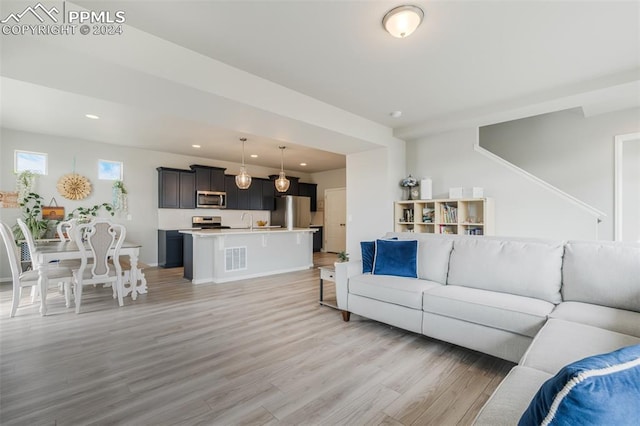 living room with light hardwood / wood-style floors and sink