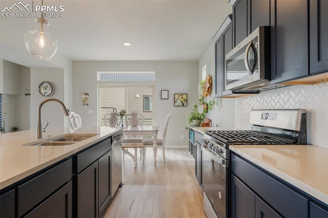 kitchen featuring a healthy amount of sunlight, pendant lighting, sink, and appliances with stainless steel finishes