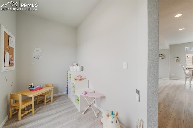 rec room featuring vaulted ceiling and light hardwood / wood-style flooring