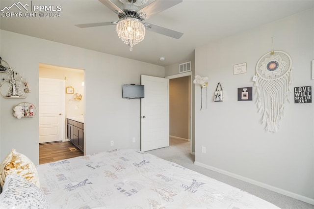 bedroom featuring light colored carpet, ceiling fan, and connected bathroom