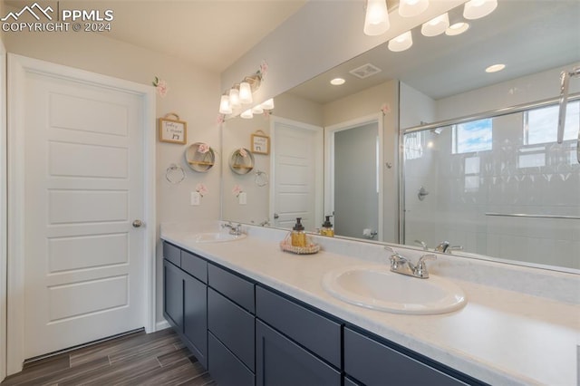 bathroom featuring a shower with door, vanity, and wood-type flooring