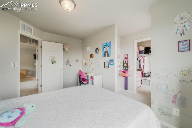 bedroom featuring a walk in closet, carpet flooring, and a closet