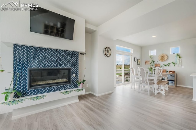 unfurnished living room featuring light wood-type flooring and a tile fireplace