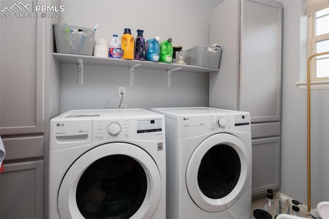 washroom featuring cabinets and washing machine and dryer