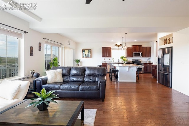 living room featuring sink, dark hardwood / wood-style flooring, and an inviting chandelier