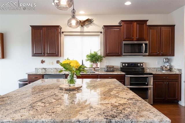 kitchen featuring pendant lighting, light stone counters, dark hardwood / wood-style flooring, and stainless steel appliances