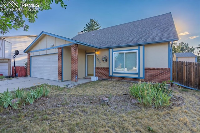 single story home with fence, concrete driveway, an attached garage, a shingled roof, and brick siding