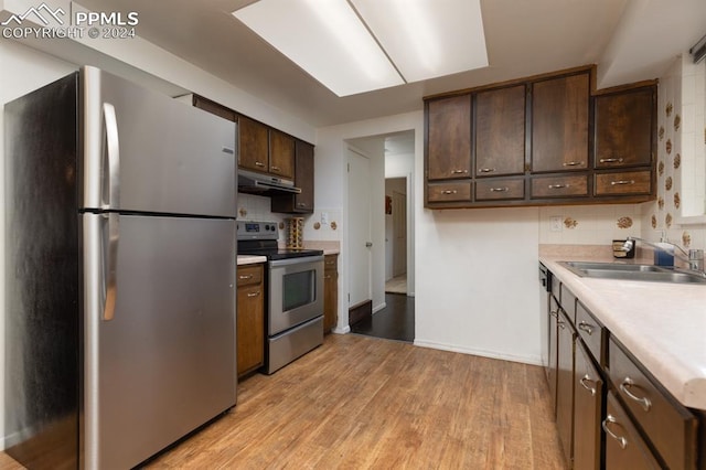 kitchen featuring light hardwood / wood-style flooring, sink, dark brown cabinetry, and appliances with stainless steel finishes