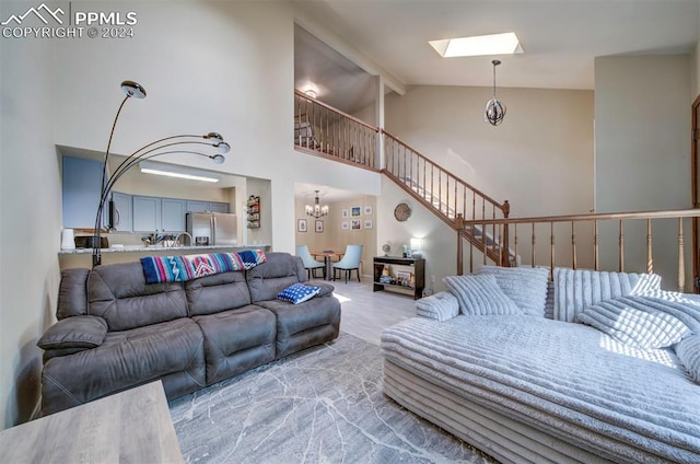 living room with a skylight, high vaulted ceiling, beam ceiling, and a notable chandelier