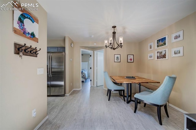 dining area featuring an inviting chandelier and light hardwood / wood-style flooring