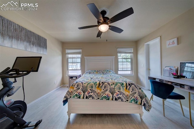 bedroom with ceiling fan and light hardwood / wood-style floors