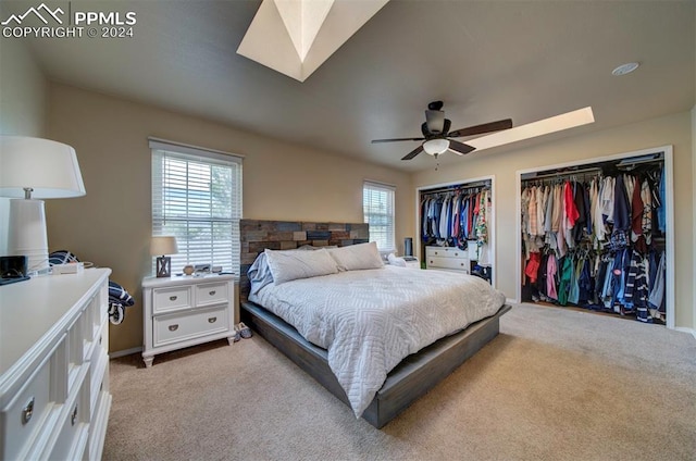 bedroom with a skylight, ceiling fan, and light carpet