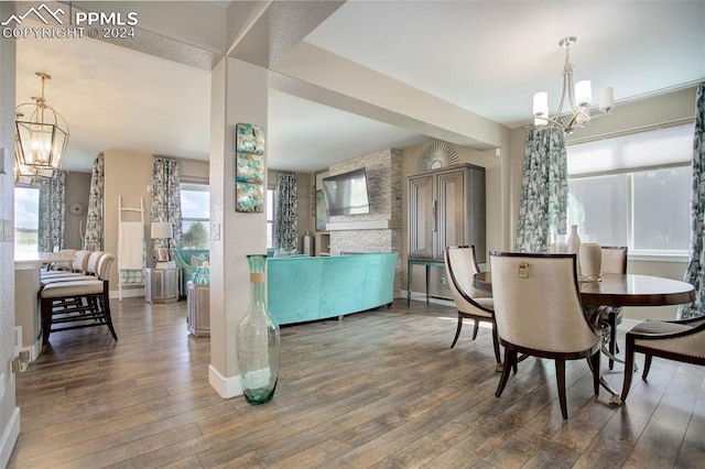 dining space featuring dark wood-type flooring, plenty of natural light, and a chandelier