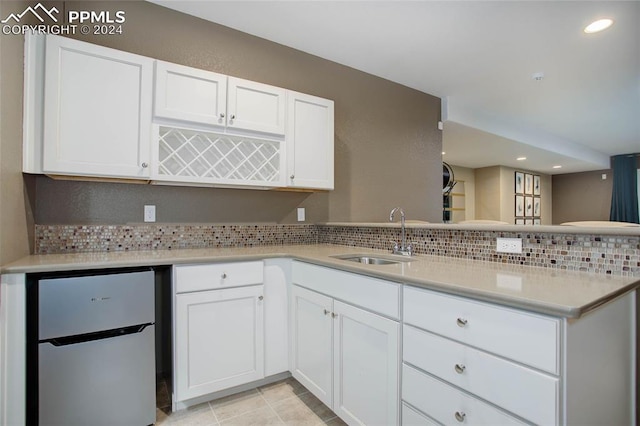 kitchen featuring white cabinets, white refrigerator, decorative backsplash, and sink