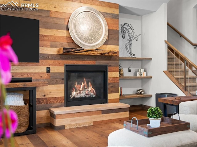 living room featuring hardwood / wood-style floors and wooden walls