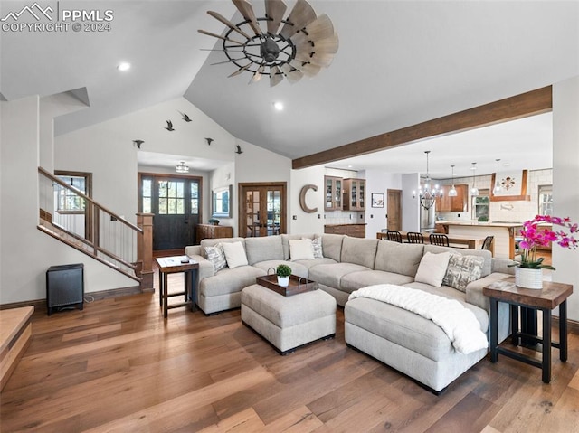 living room with dark wood-type flooring, high vaulted ceiling, and a notable chandelier