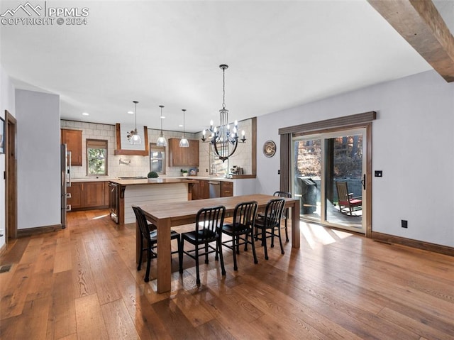 dining space featuring wood-type flooring and a chandelier