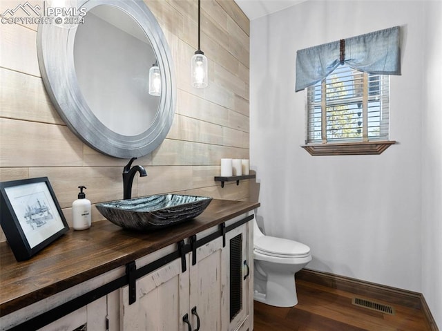 bathroom with toilet, hardwood / wood-style flooring, tasteful backsplash, and vanity