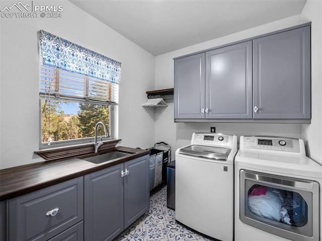 laundry room featuring cabinets, sink, and washing machine and dryer