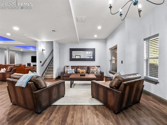 living room with dark hardwood / wood-style flooring and a notable chandelier