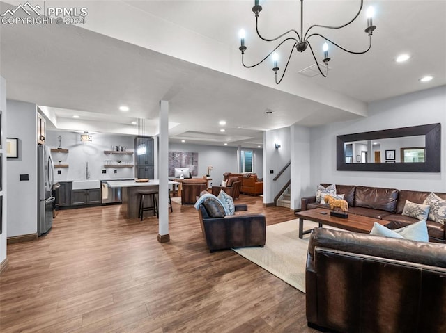 living room featuring dark hardwood / wood-style flooring, sink, and a notable chandelier