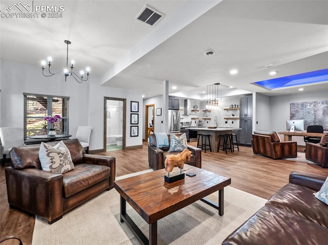 living room with light wood-type flooring and a chandelier