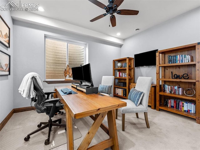 carpeted home office featuring ceiling fan