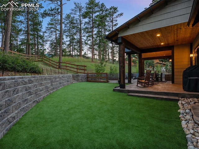 yard at dusk featuring a wooden deck