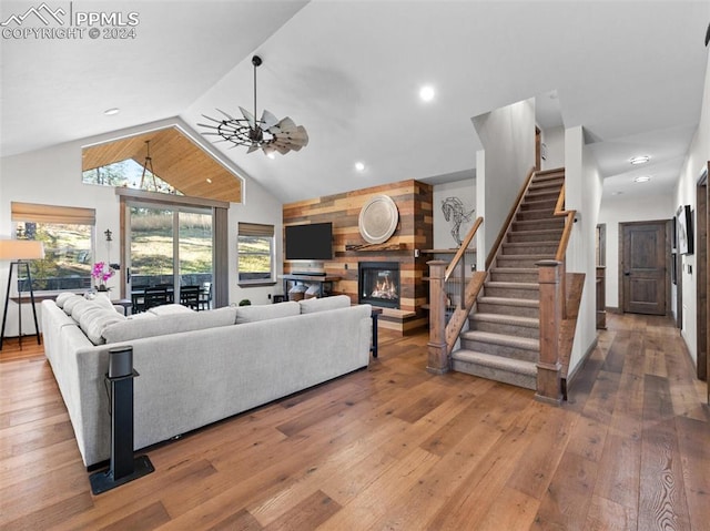 living room featuring hardwood / wood-style floors, ceiling fan, a fireplace, and wooden walls