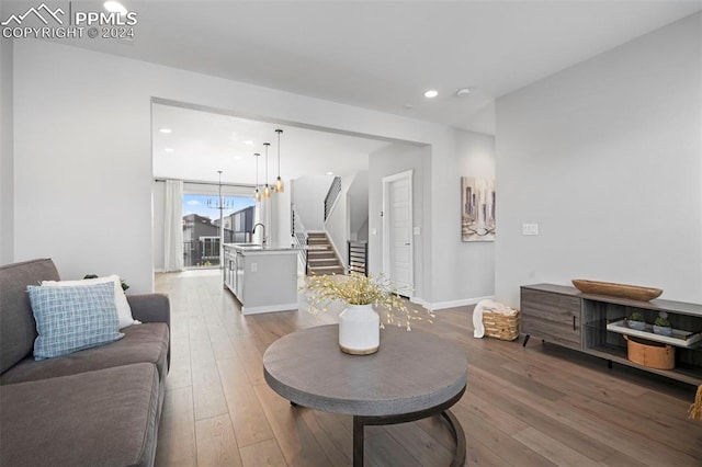 living room featuring sink, hardwood / wood-style floors, and a notable chandelier