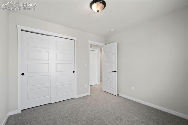 unfurnished bedroom with a closet and carpet flooring