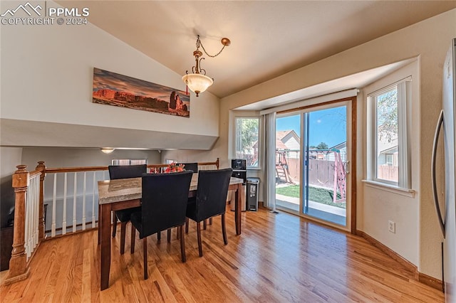 dining space featuring vaulted ceiling and light hardwood / wood-style floors