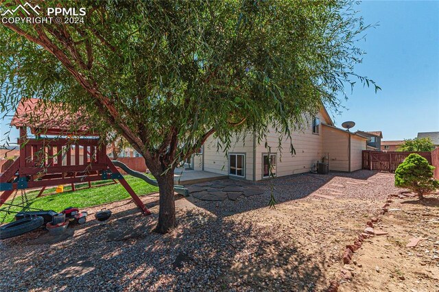 view of yard with a playground, a patio, and central AC