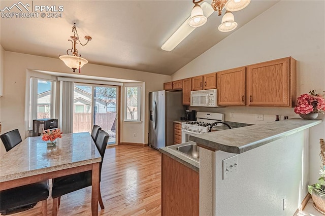 kitchen featuring vaulted ceiling, hanging light fixtures, light wood-type flooring, kitchen peninsula, and white appliances