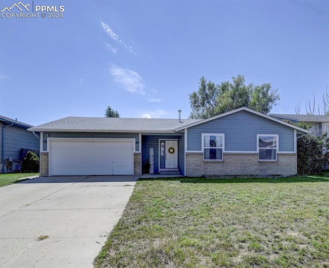 ranch-style house featuring a garage and a front lawn