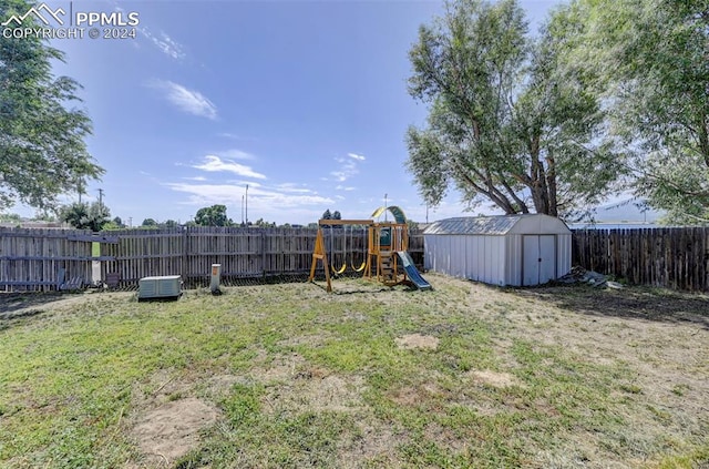 view of yard featuring a storage unit and a playground