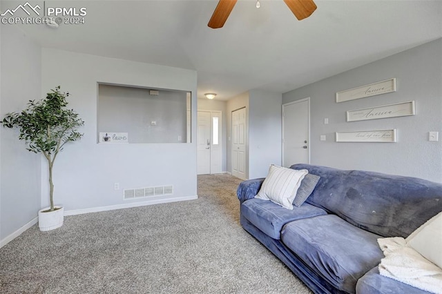 living room with ceiling fan and carpet