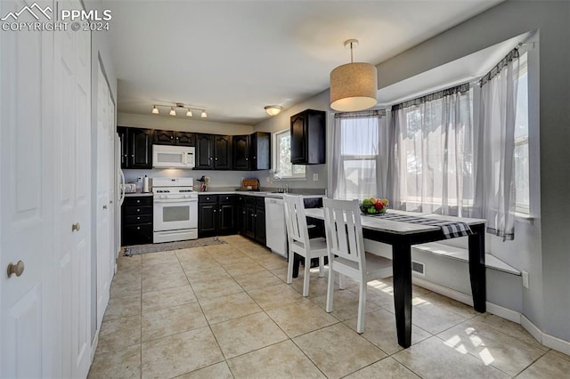 kitchen with pendant lighting, white appliances, a wealth of natural light, and dark brown cabinets