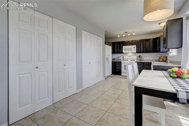 kitchen with sink, light tile patterned floors, white appliances, and dark brown cabinets